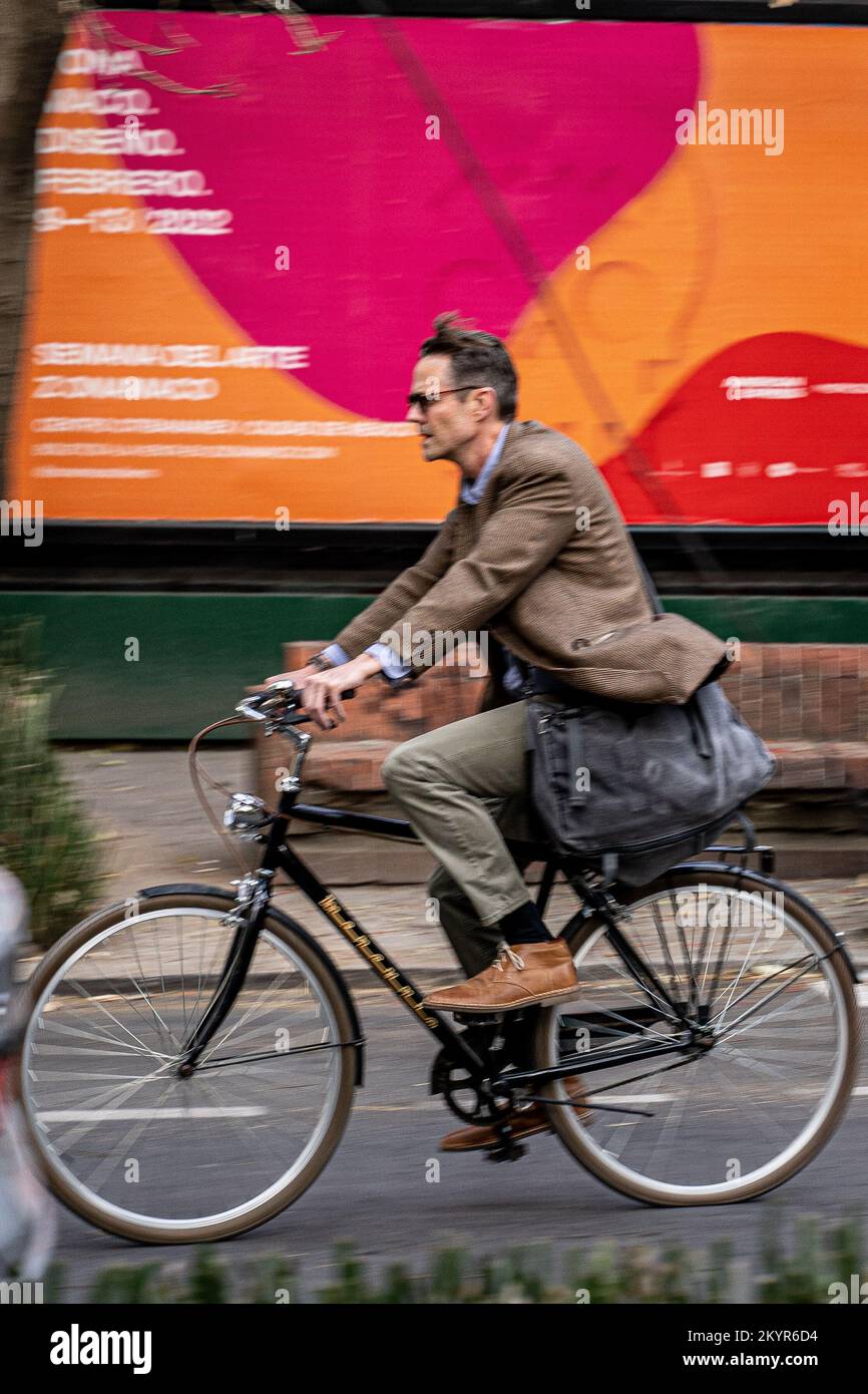 Middle aged man commuting on a bicycle in Mexico City Stock Photo