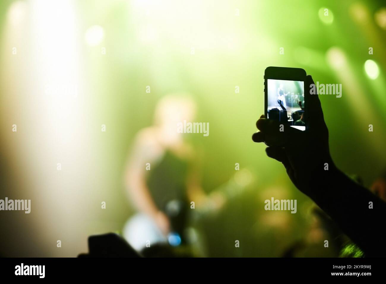 Capturing the moment. A person filming their favourite band with a camera phone. Stock Photo