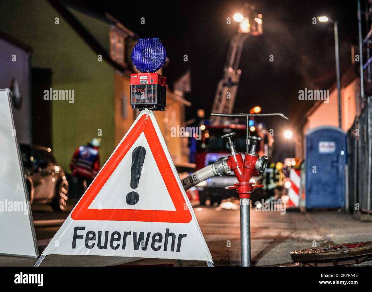 Urbach, Germany. 01st Dec, 2022. A fire department set-up man secures a hydrant. A fire in the family house caused damage of about 400 000 euros. The 56-year-old homeowner had put a pot with hot ashes on the terrace on Thursday evening. According to the report, the pot had ignited and started a fire that spread to the facade, the house entrance and finally the attic. (to dpa: 'Pot with hot ash on balcony: residential building burns down') Credit: Kohls/SDMG/dpa/Alamy Live News Stock Photo