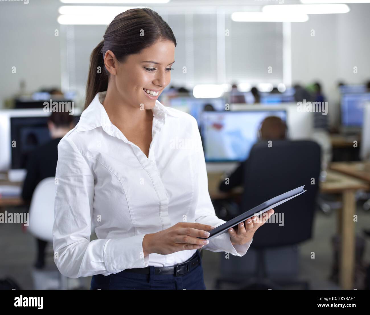 Keep abreast of online developments. A gorgeous young business woman using her digital tablet in the office. Stock Photo