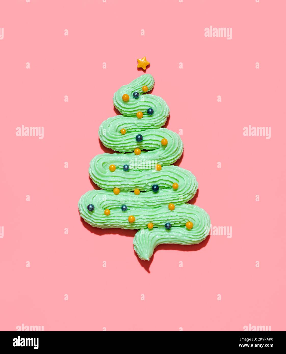 Green buttercream frosting in the shape of a Christmas tree with colored sugar sprinkles as Christmas baubles. Edible Christmas tree made from mint fr Stock Photo