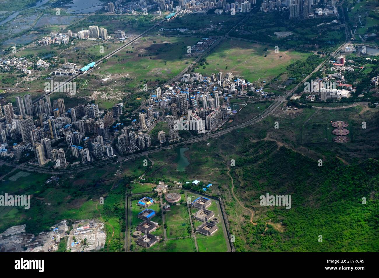 An aerial view of Mumbai's skyline passing over a building with roads ...