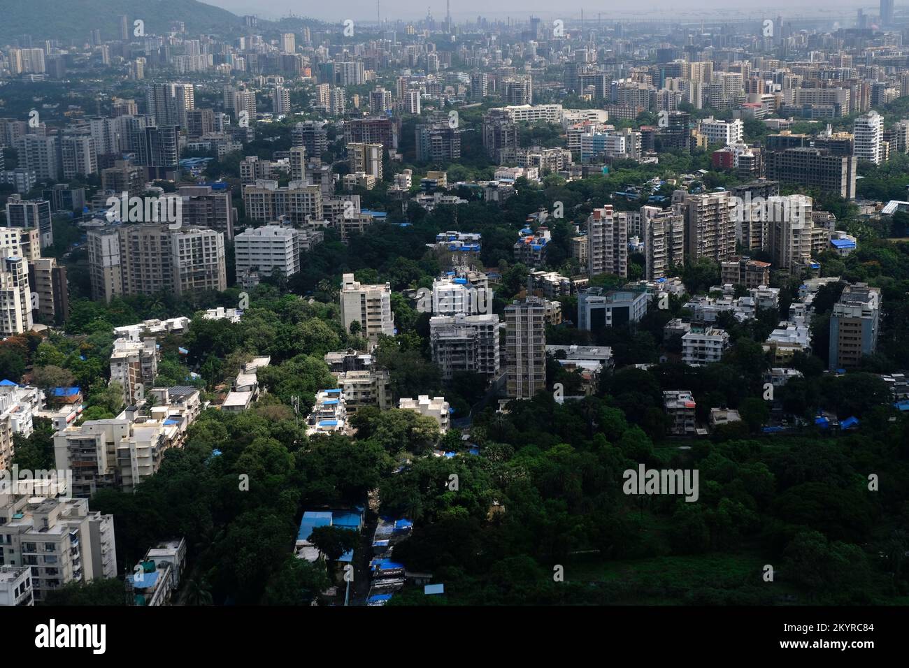 An aerial view of Mumbai's skyline passing over a building with roads ...