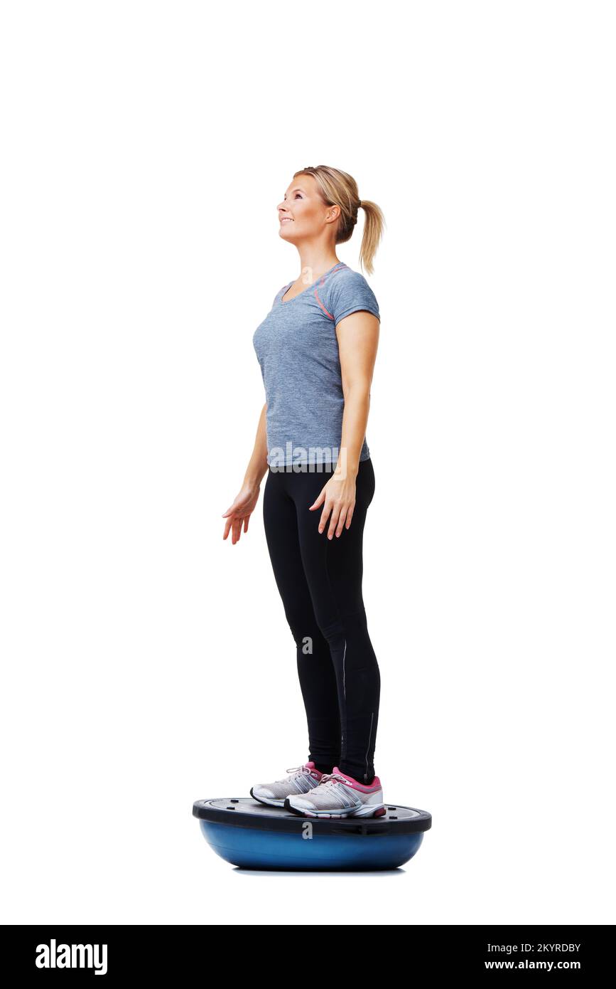 Her daily exercise routine. A beautiful young woman standing on a bosuball while working out