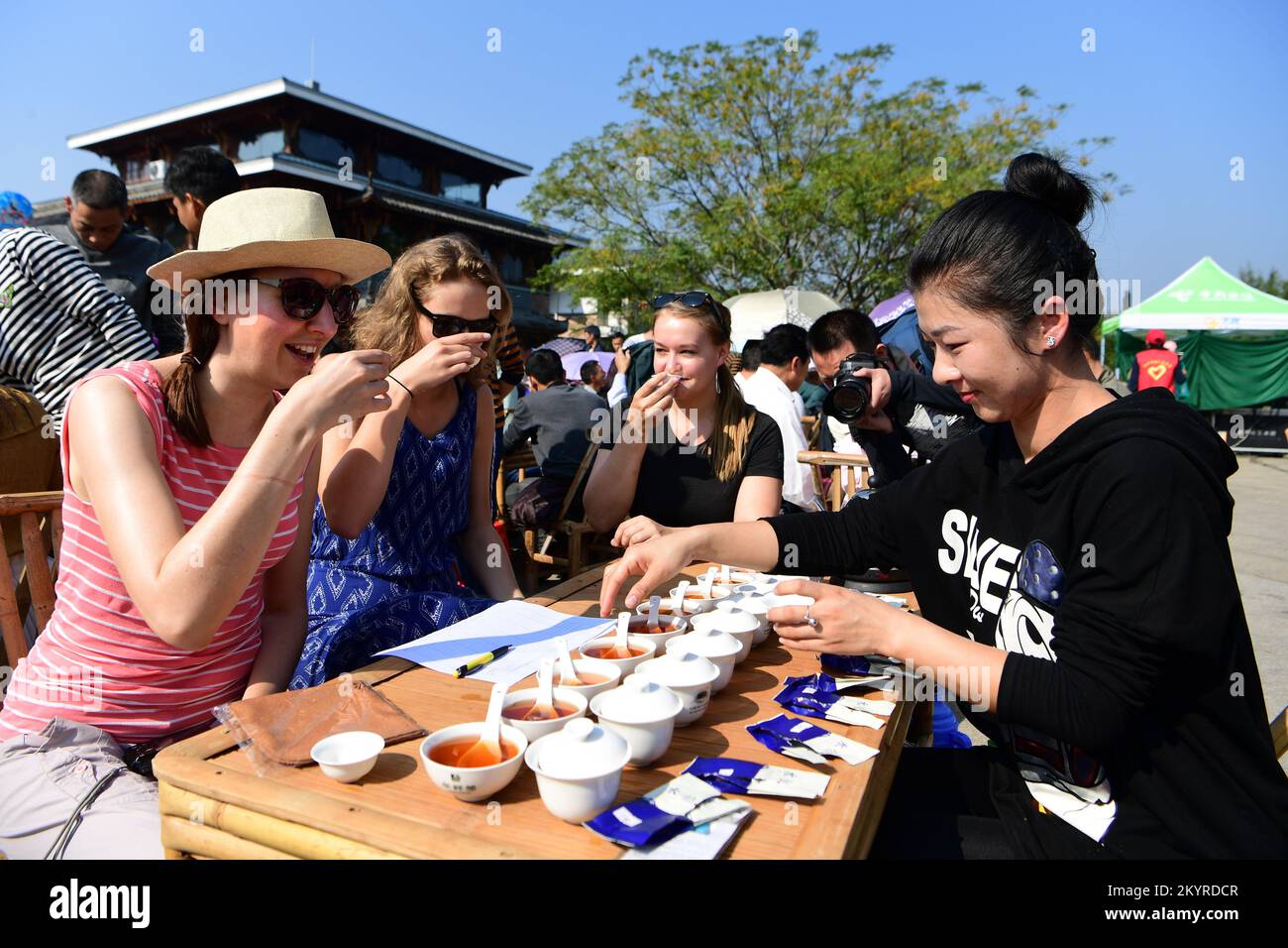 WUYISHAN, Dec. 2, 2022 (Xinhua) -- Foreign visitors taste Wuyi rock tea at a tea tasting competition in Wuyishan, southeast China's Fujian Province, Oct. 28, 2017. Wuyishan, the hometown of rock tea, boasts a wide range of rock tea varieties. The making technique of Wuyi rock tea, a special oolong variety with a particularly roasted taste and floral and fruity aroma, is comprised of more than 10 processing procedures including tea harvesting, withering, fixation, twisting, drying and so on. Inherited and developed with a long history, the making technique of Wuyi rock tea is liste Stock Photo