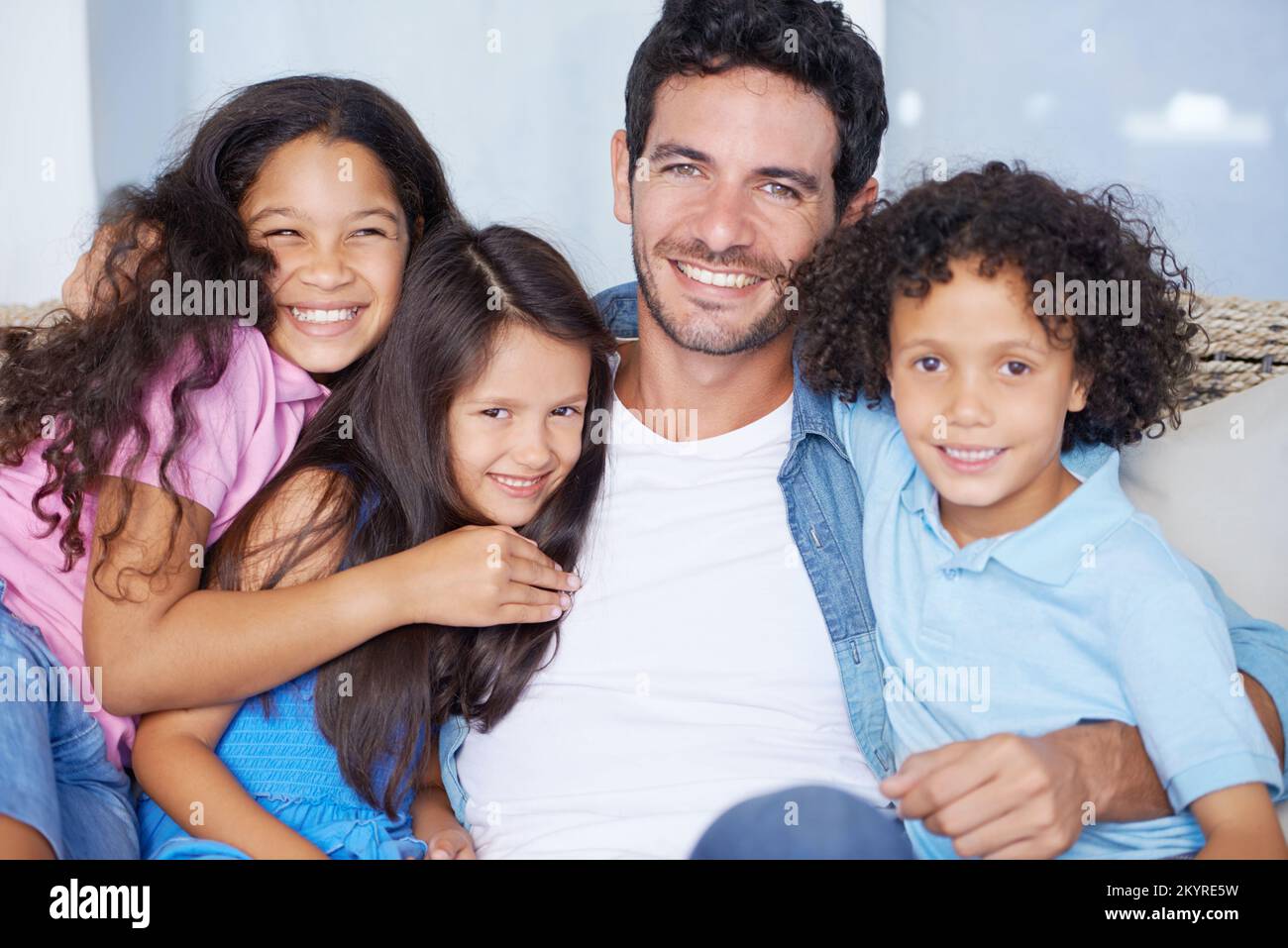 Family ties of love. Portrait of a happy single parent family sitting on a sofa and smiling at the camera. Stock Photo