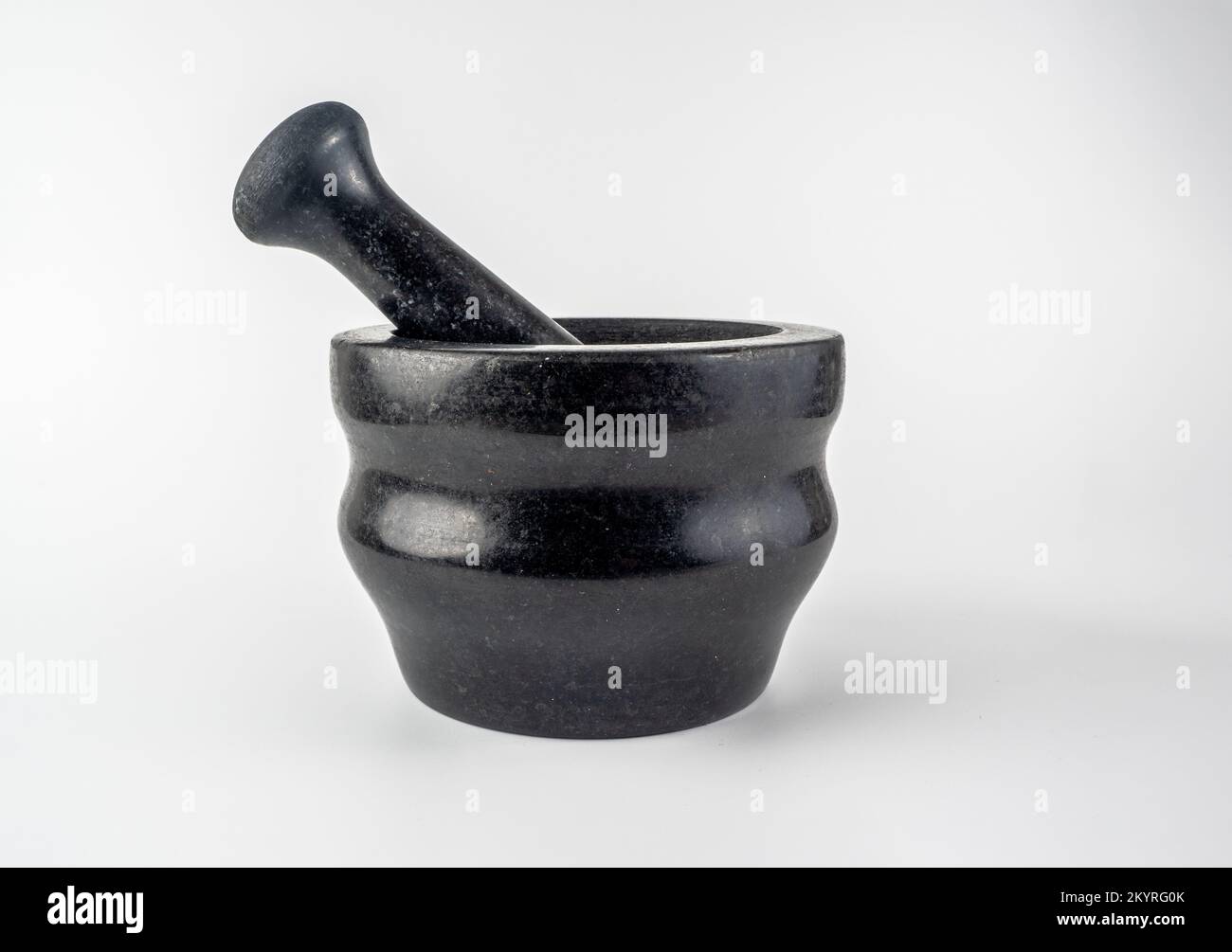 traditional black granite mortar and prestle isolated on a white ...