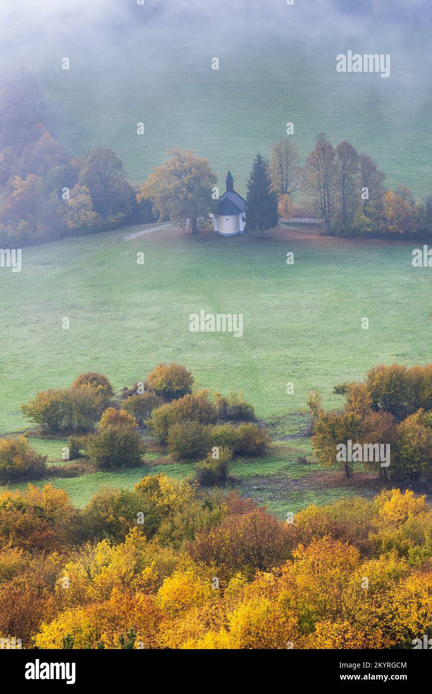 Autumn foggy country with a chapel under the Podskalsky Rohac hill in Strazov Mountains Protected Landscape Area, Slovakia, Europe. Stock Photo