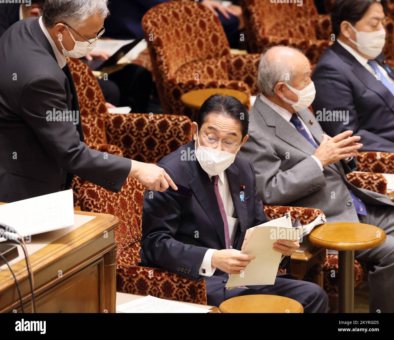 Tokyo, Japan. 2nd Dec, 2022. An official (L) dusts Japanese Prime Minister Fumio Kishida's jucket before starting Upper House's budget committee session at the National Diet in Tokyo on Friday, December 2, 2022. Japan's supplementary budget bill will be passed Upper House on December 2. Credit: Yoshio Tsunoda/AFLO/Alamy Live News Stock Photo