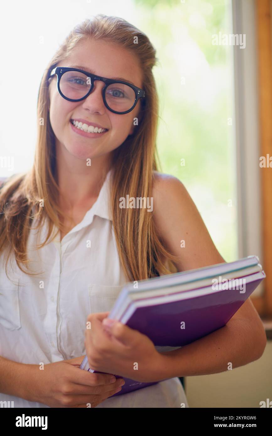 Studying is never a chore for me. a young girl in her school hallway. Stock Photo