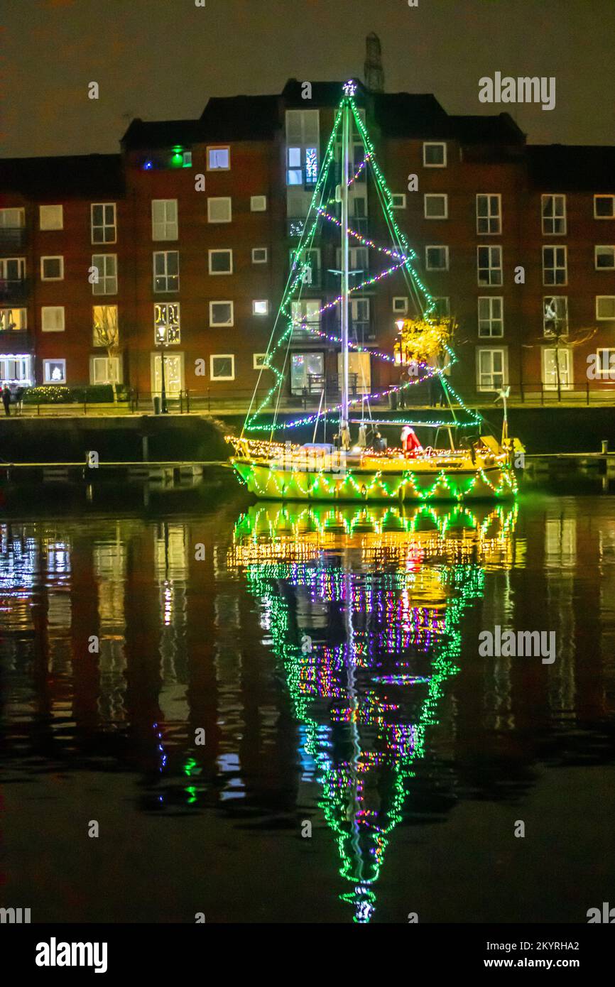 Christmas Lights at Sea. A Bright Holiday Boat Parade in Preston, Lancashire Dec 2022. Moored yachta & Sailing boats decorated with sparkling Christmas lights in Preston Marinaa.  A Christmas night switch on for the crowds lining the dock wall as berth holders light up their boats and enjoy an evening sail under Festive Lights. Stock Photo