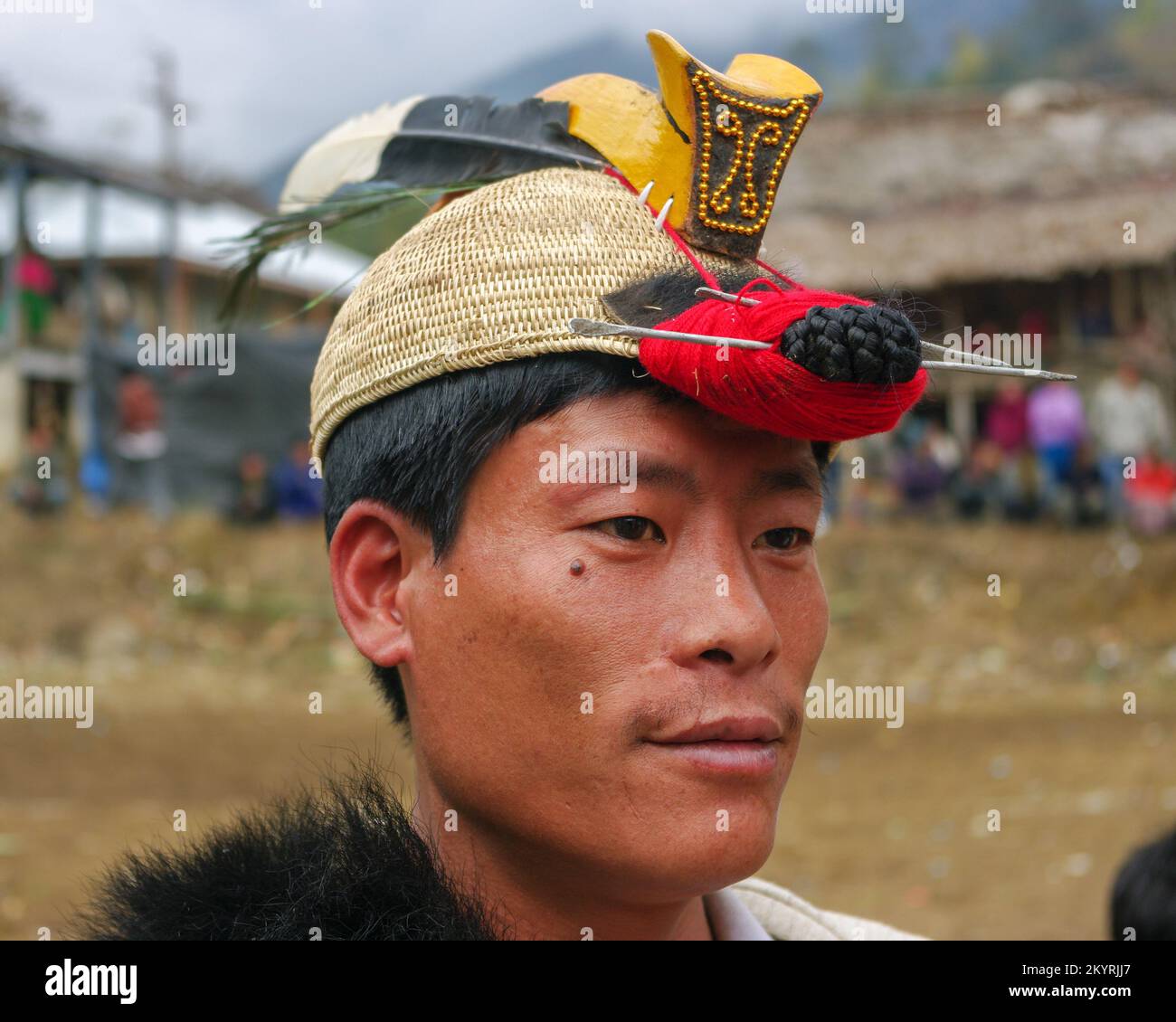 Raga, Arunachal Pradesh, India - 02 25 2009 : Portrait of young Nyishi tribe man wearing traditional cane headgear with hornbill beak and feathers Stock Photo