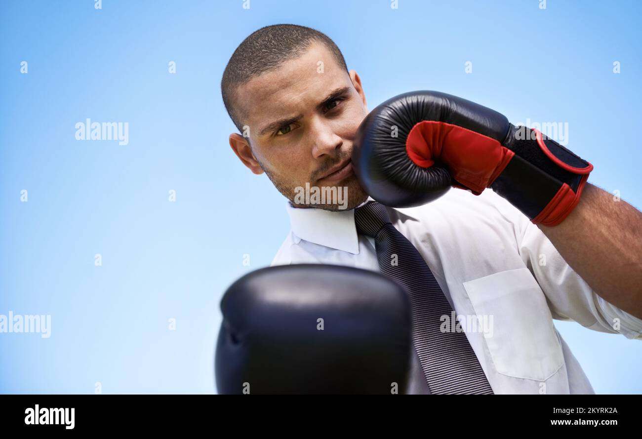 Punching out the competition. A businessman wearing boxing gloves. Stock Photo