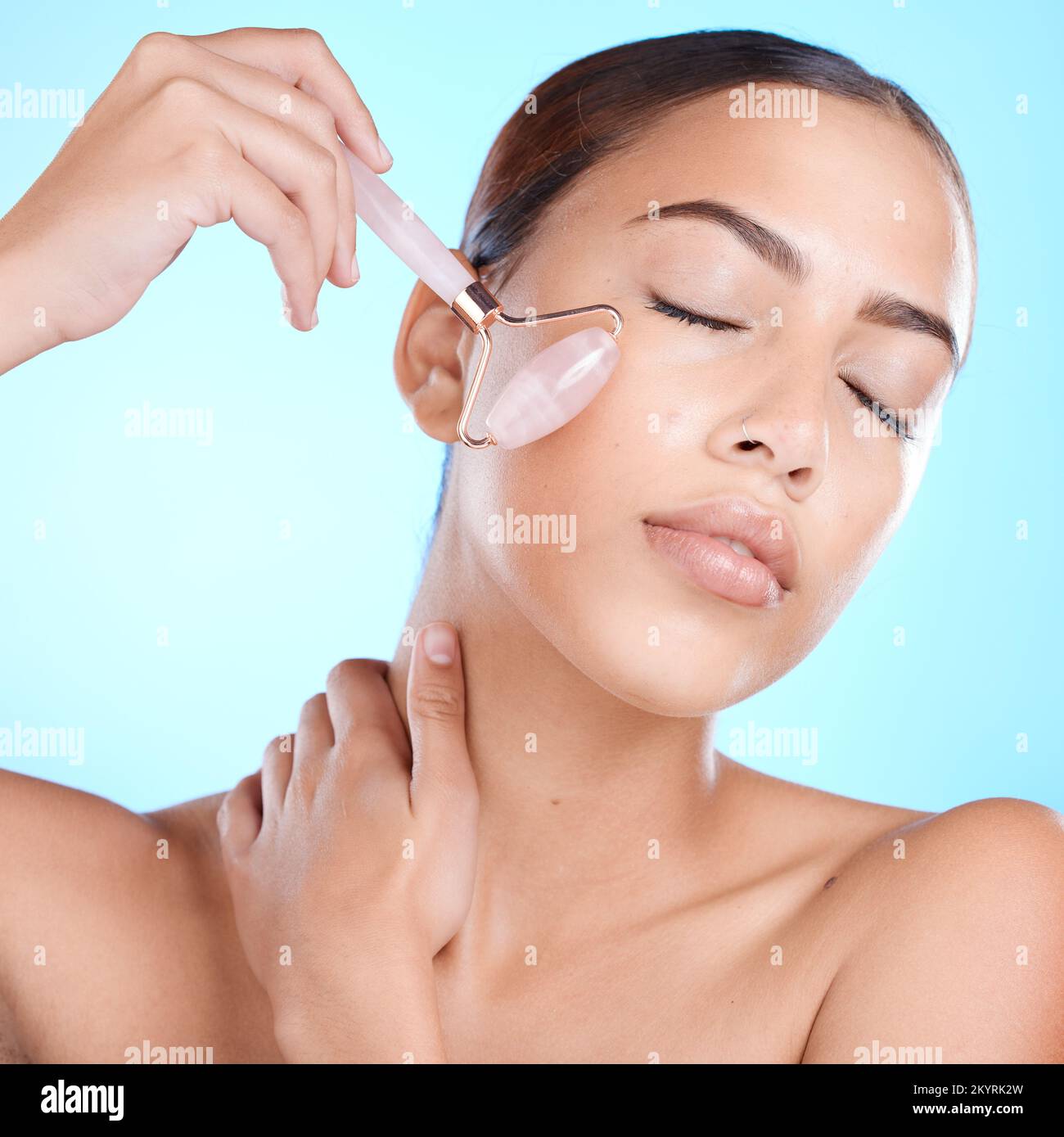 Beauty, face and roller tool for cosmetic luxury skincare health on blue studio background. Facial massage accessory, anti aging cosmetics routine and Stock Photo