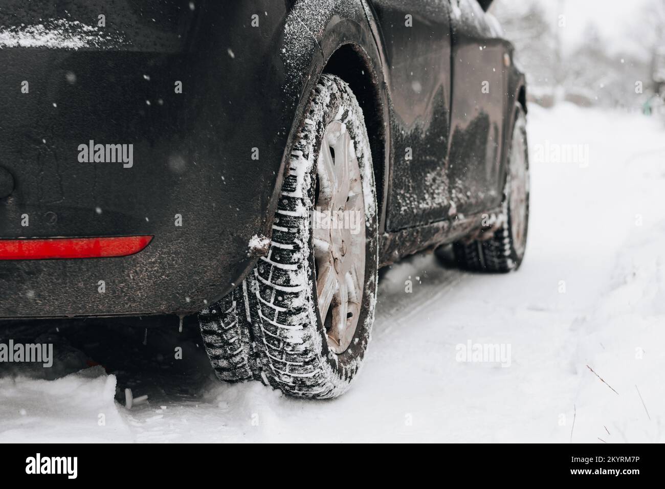 Winter tire. Car on snow road. Tires on snowy highway detail Stock