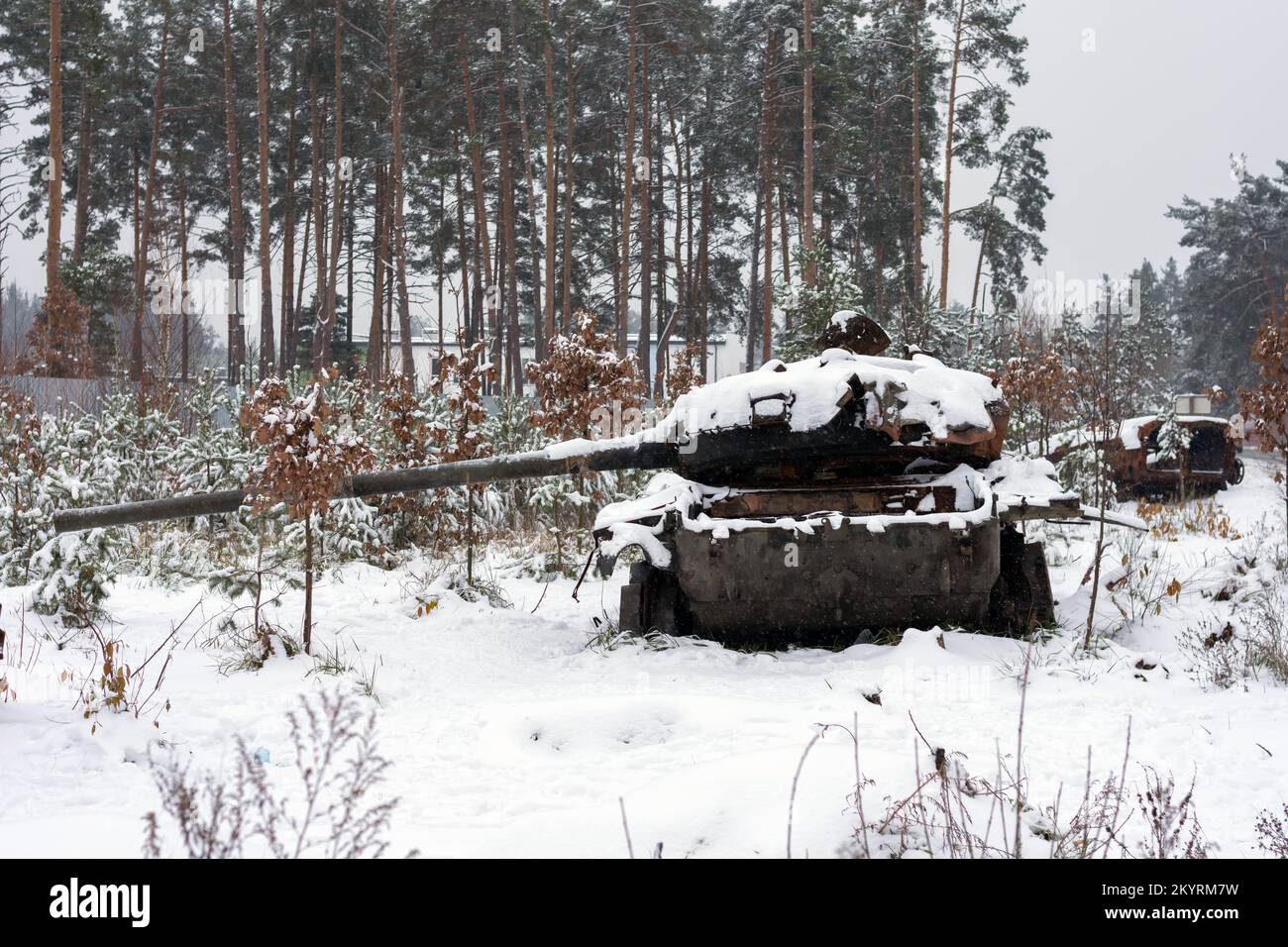 Russian battle tank in the snow which was destroyed on the roadside of highway during hostilities in Russian invasion of Ukraine, 2022. War in Ukraine Stock Photo