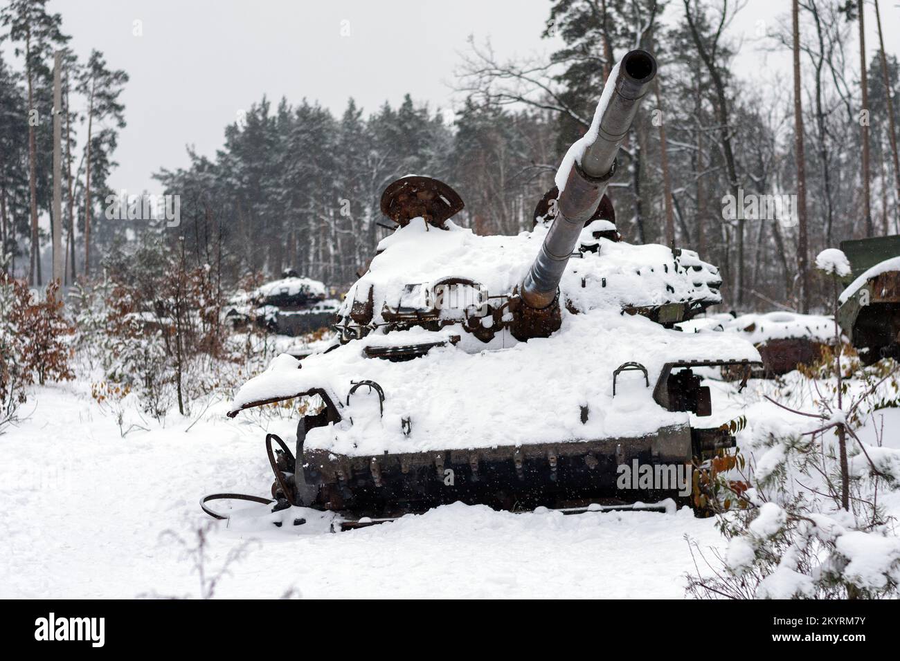 Russian battle tank in the snow which was destroyed on the roadside of highway during hostilities in Russian invasion of Ukraine, 2022. War in Ukraine Stock Photo