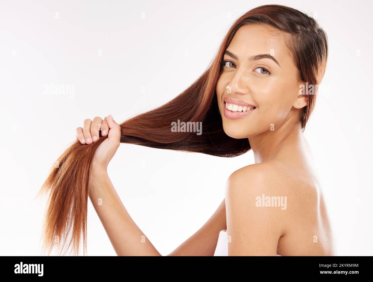 Woman, beauty and holding long hair in studio background with smooth texture, shine and wellness