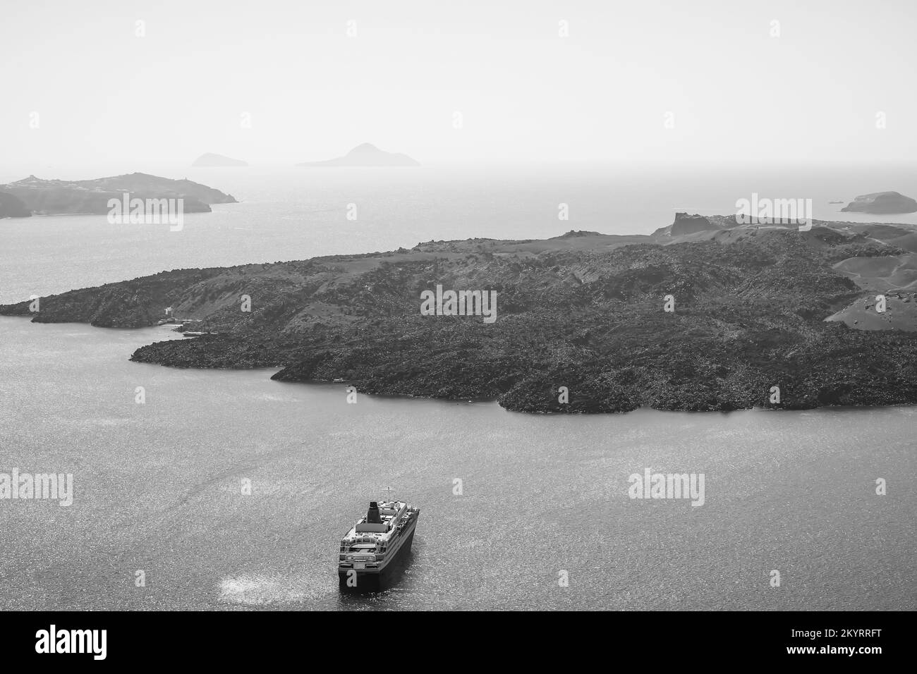 Santorini, Greece - September 16, 2022 : View of a cruise liner next to the famous volcano of Santorini in black and white Stock Photo