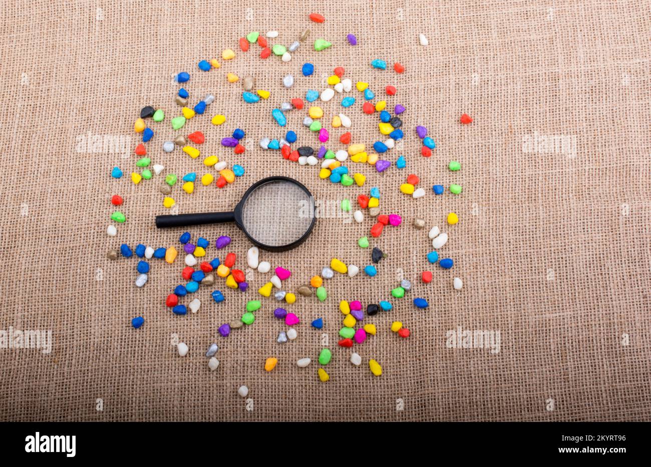 Magnifying glass amid Colorful pebbles Stock Photo - Alamy