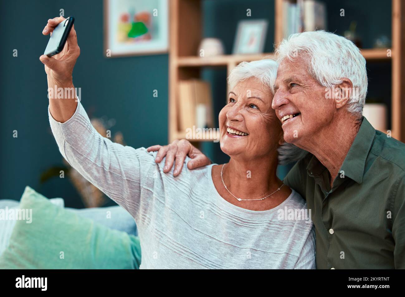 Couple, elderly and selfie with smile and retirement, woman holding smartphone for picture with man and happy at home. Bond, commitment and marriage Stock Photo