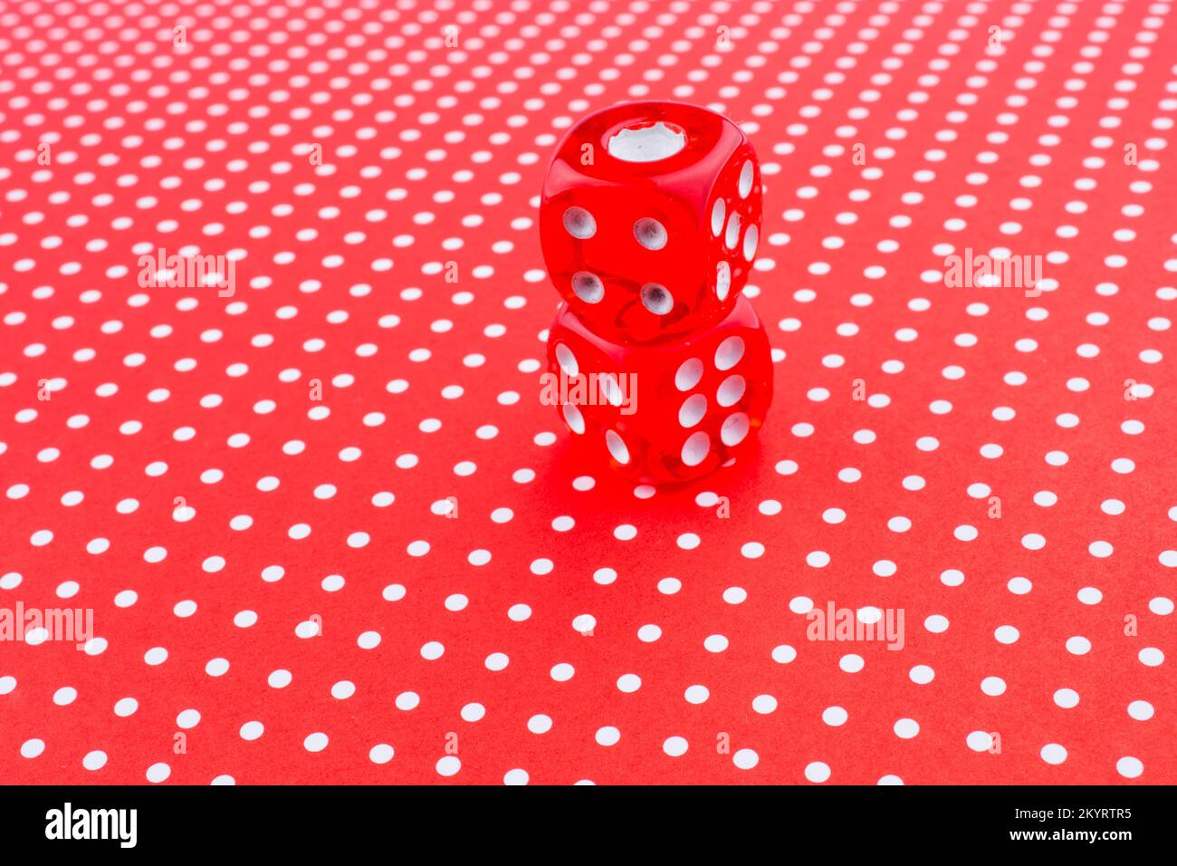 Red dice on a red background Stock Photo - Alamy