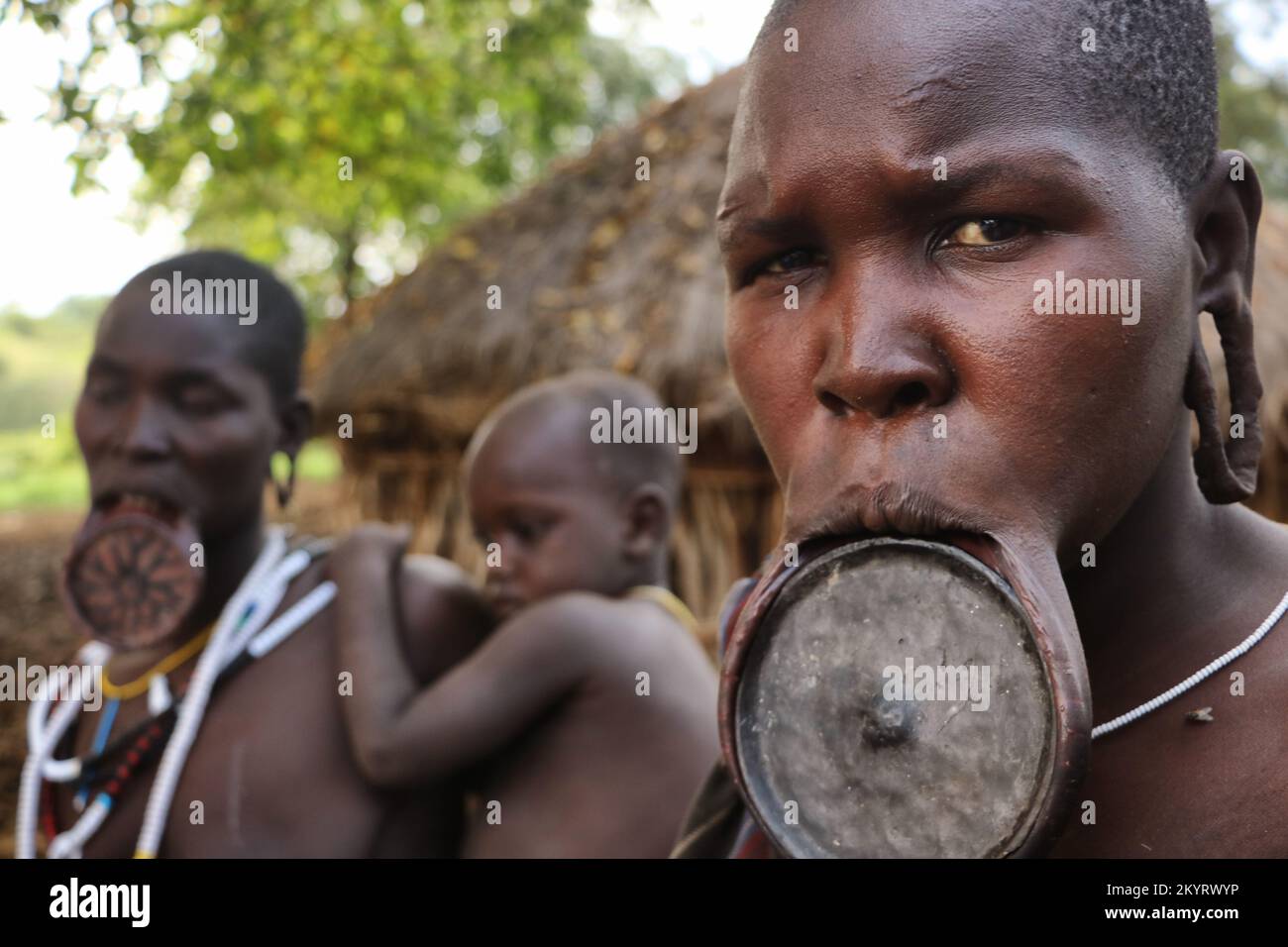 Mursi women with labial plate and son, ethnic minorities of the lower Omo valley - Ethiopia. Stock Photo