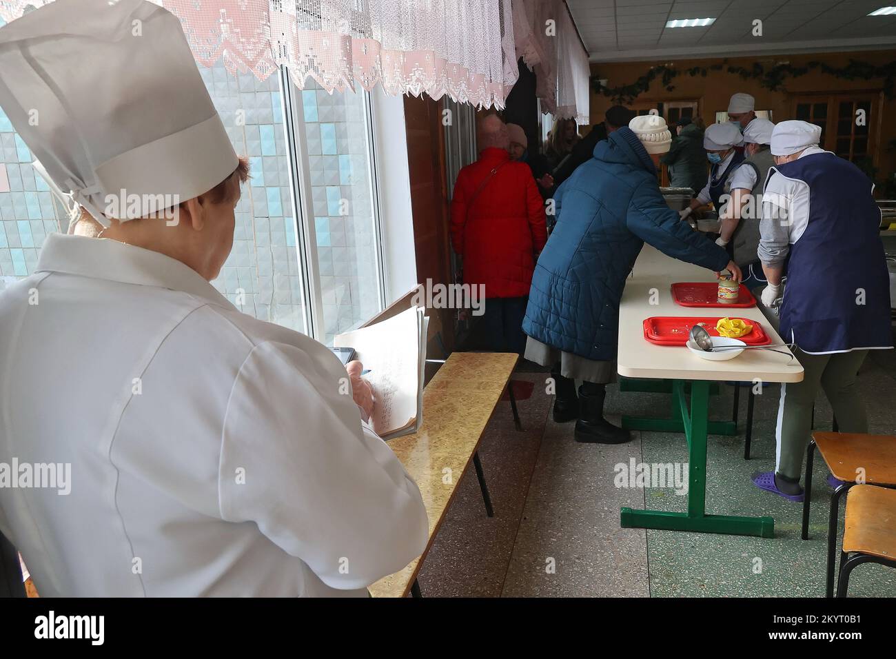 KHARKIV, UKRAINE - DECEMBER 01, 2022 - Employees of a food distribution point clean the tables after the visitors, Kharkiv, northeastern Ukraine. Stock Photo