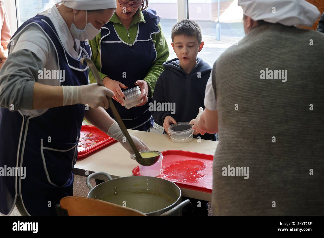 KHARKIV, UKRAINE - DECEMBER 01, 2022 - Employees of a food distribution point serve hot meals to the visitors, Kharkiv, northeastern Ukraine. Stock Photo