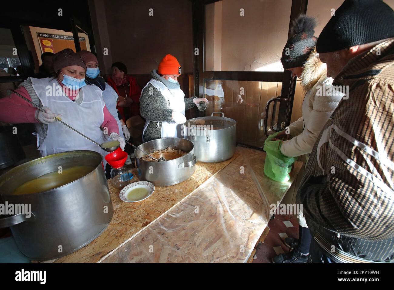 KHARKIV, UKRAINE - DECEMBER 01, 2022 - Employees of a food distribution point pour hot soup into the bowls, Kharkiv, northeastern Ukraine. Stock Photo