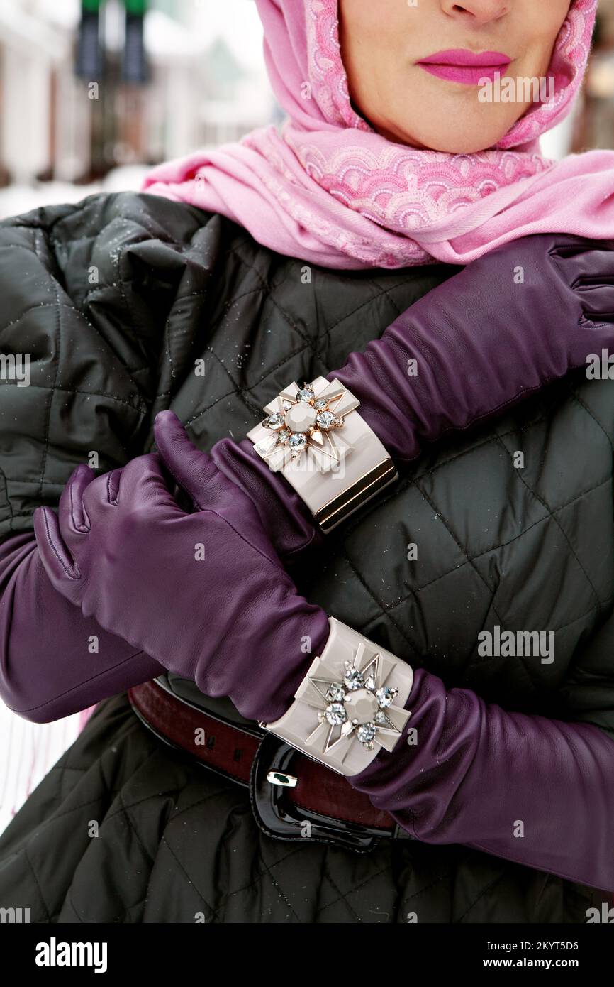 Woman stylish leather gloves and bracelets, elegant head scarf and quilted coat. Fashionable female clothing and accessories Stock Photo