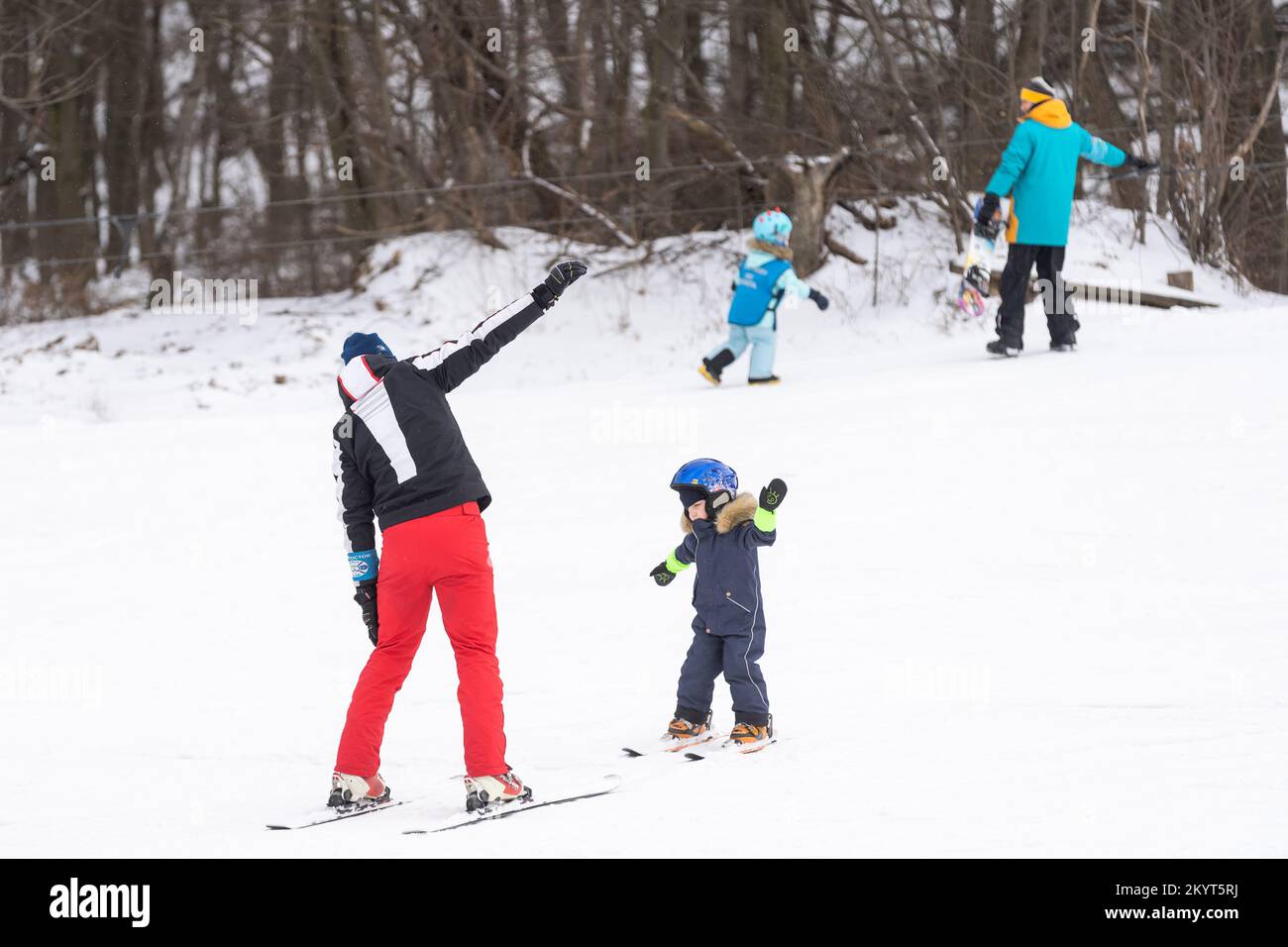 Instructor and little child skiing. toddler kid with safety helmet. Ski