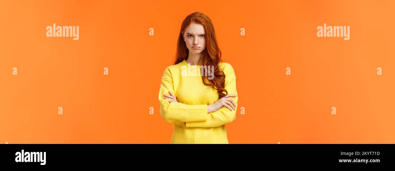 I am mad. Offended sulky cute and timid redhead curly girl, cross arms chest, sulking angry and tensed, frowning stare disappointed someone sad rude Stock Photo