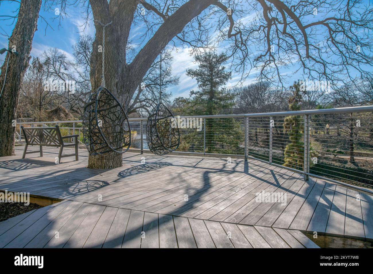 Wooden walkway with swings and bench at the San Antonio River Walk in