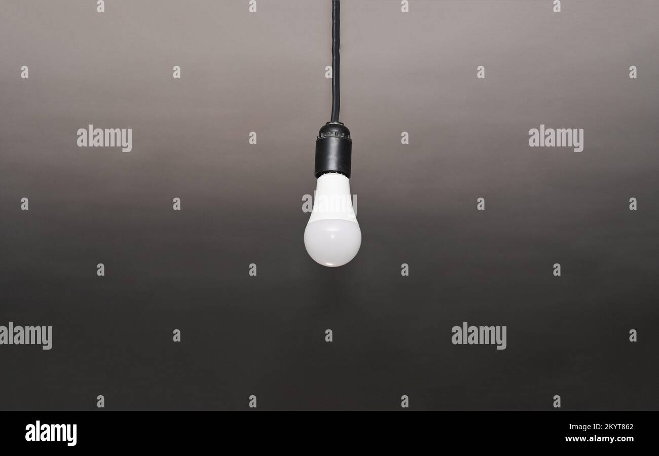 a lamp hanging on a cable. lonely LED bulb Stock Photo Alamy