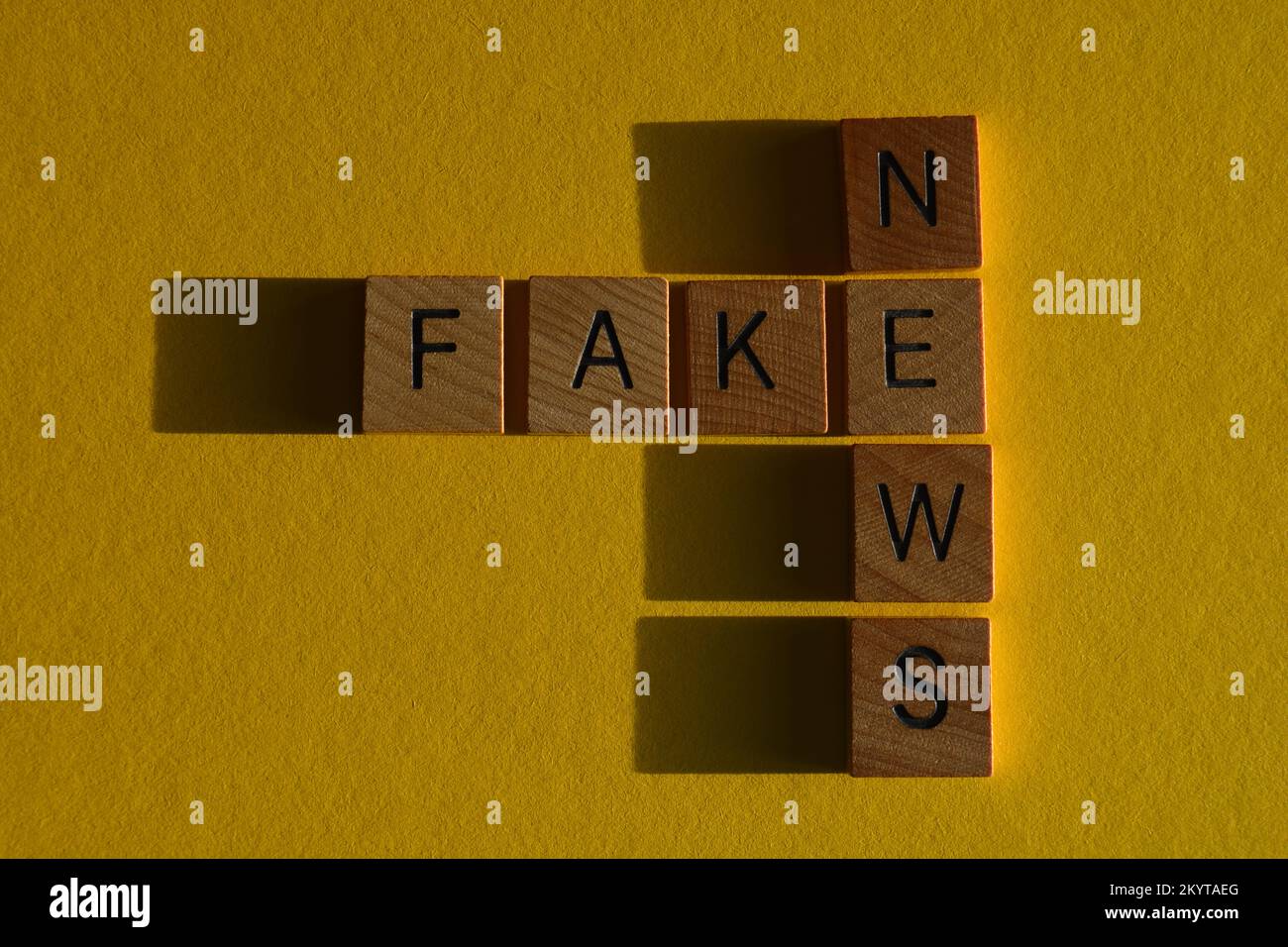 Fake News, words in wooden alphabet letters in crossword form isolated on yellow background Stock Photo