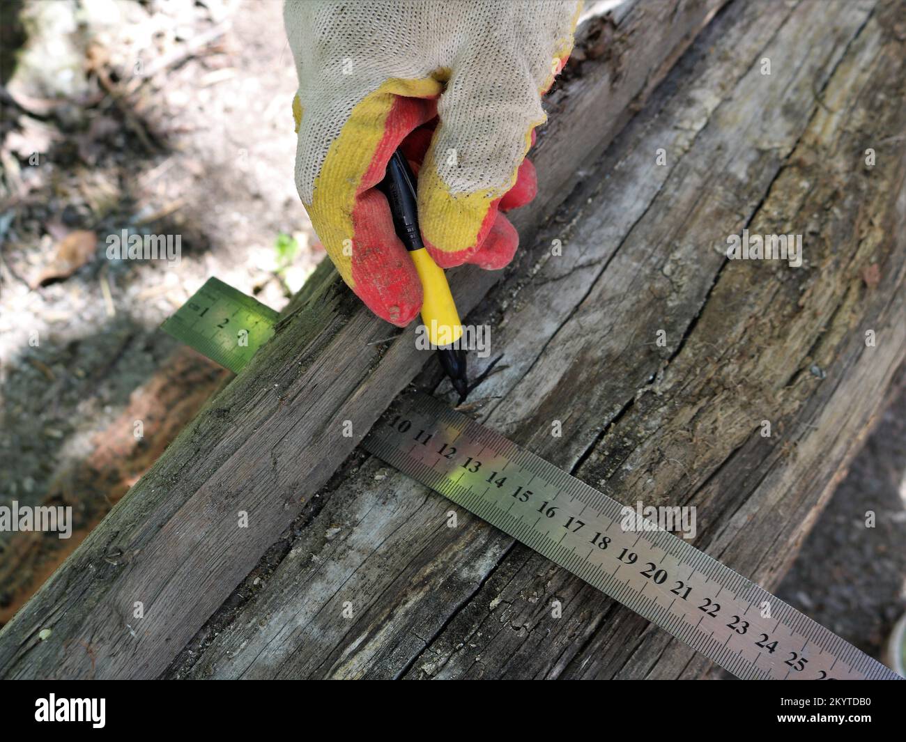 marker in a hand in a fabric glove making a mark on the surface of an