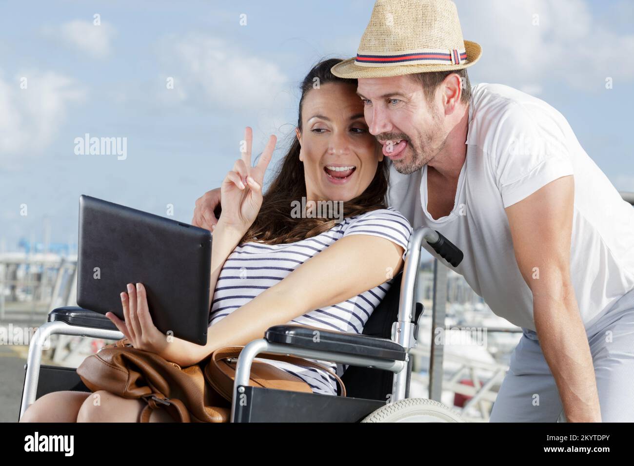 young woman in wheelchair and her husband taking selfie outdoors Stock ...