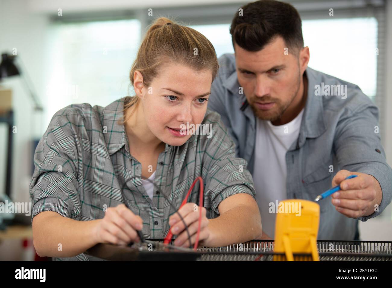 male and female engineer using soldering iron Stock Photo Alamy