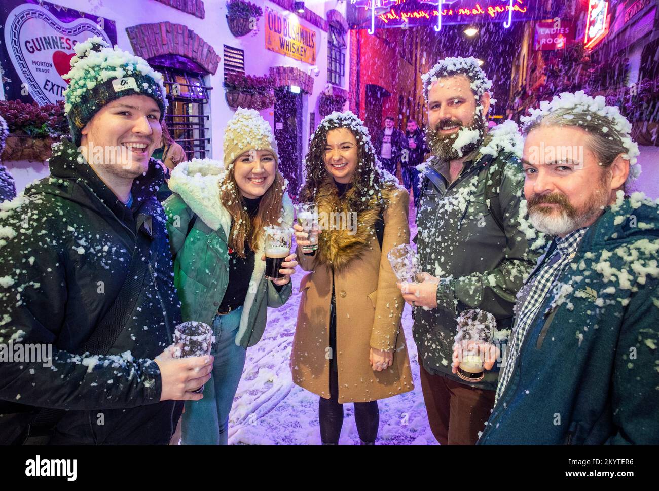 (Left-right) Jack Penton, Jamie Doherty, Emma Curran, Chris Laughlin, and Paul Barrett on the cobbled streets of Commercial Court outside the Duke of York bar in Belfast as Guinness brought its iconic Christmas ad to life with a snow machine as guests were treated to a pint to start the festive season. Stock Photo