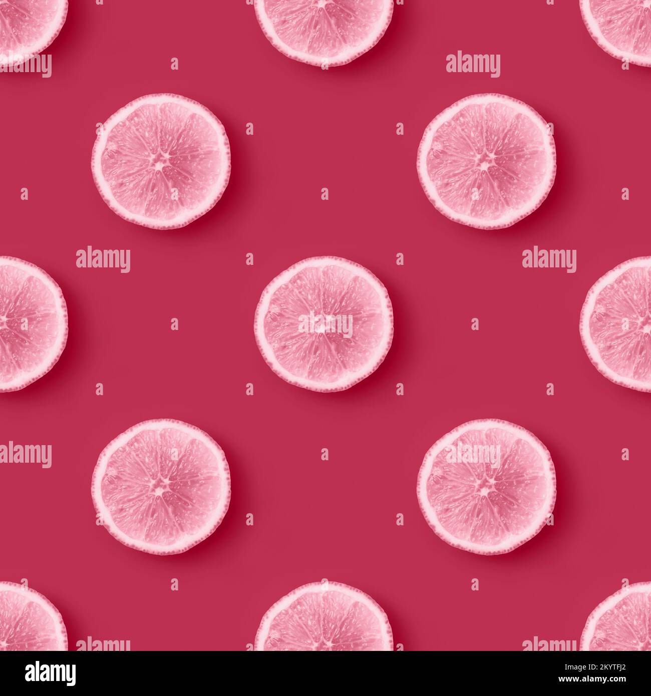 Citrus slices on magenta background seamless endless pattern. Color of the Year 2023 Viva Magenta. Flat lay Stock Photo