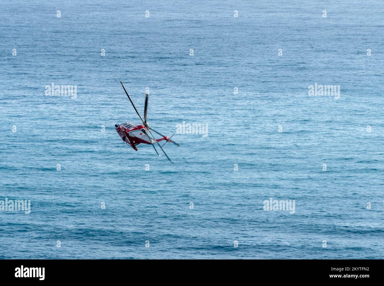 Helicopter flying over open sea seen in Italy Stock Photo