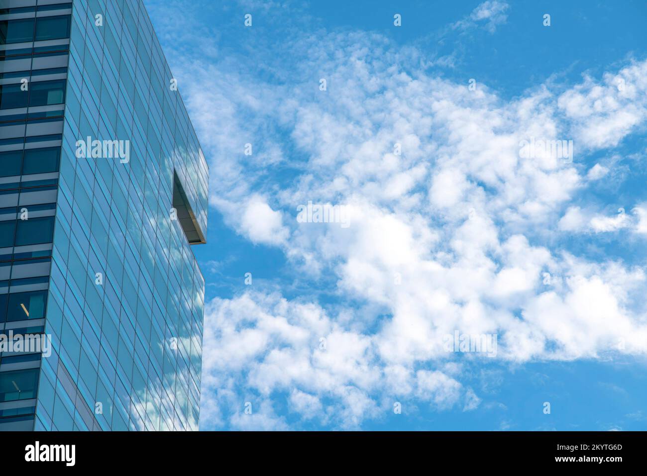 Austin, Texas- Glass building camouflage against the cloudy sky. Exterior of a building with a semi-transparent view because of the glass walls. Stock Photo