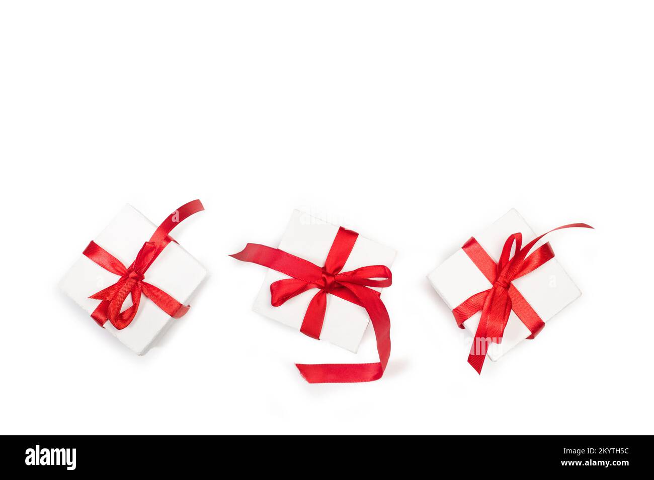 Three white boxes with red bows on a white background with copy space Stock Photo