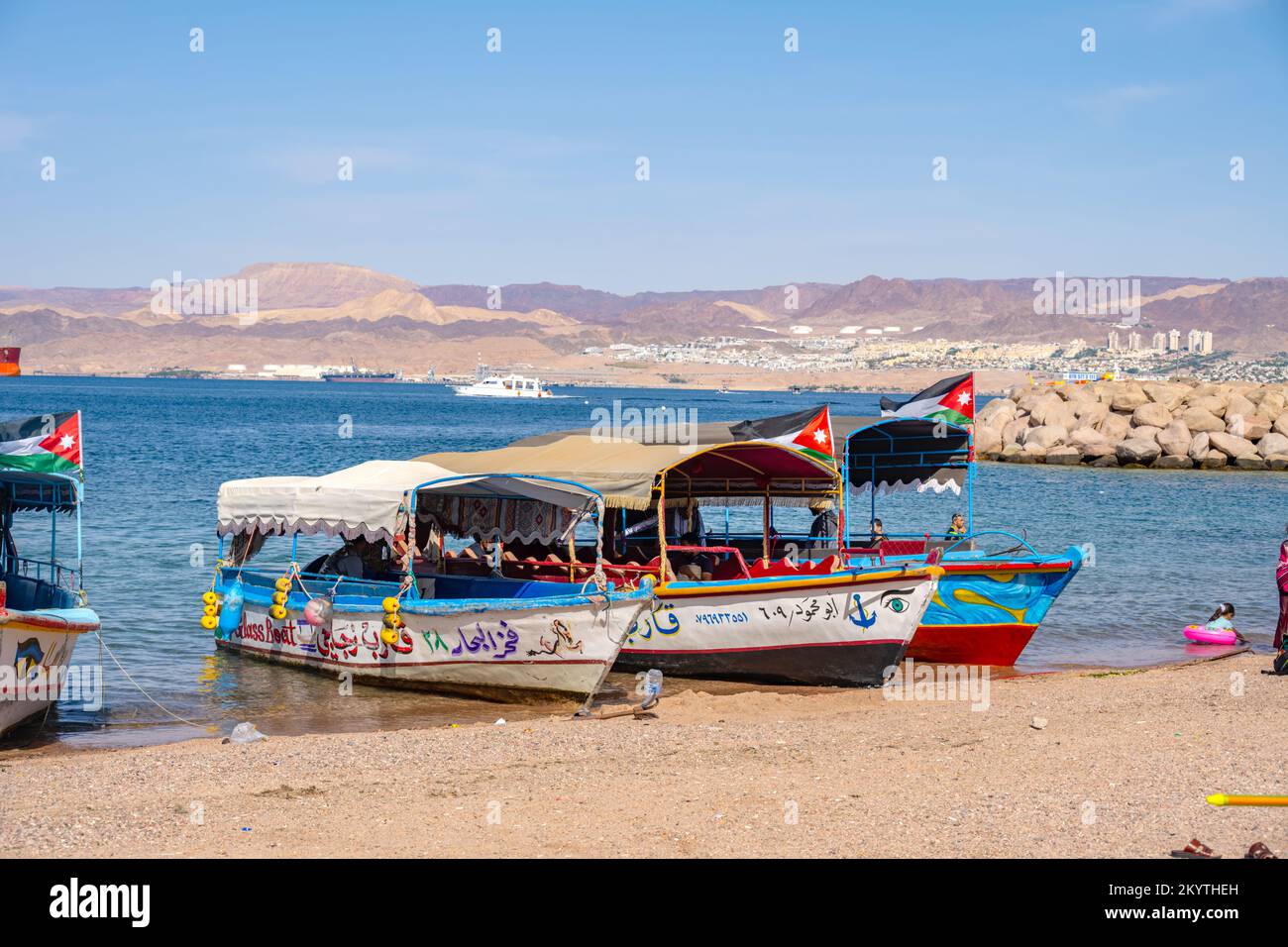 Boats pulled up on Al-Ghandour Beach in Aqaba Jordan looking towards the hills of Isreal and Egypt Stock Photo