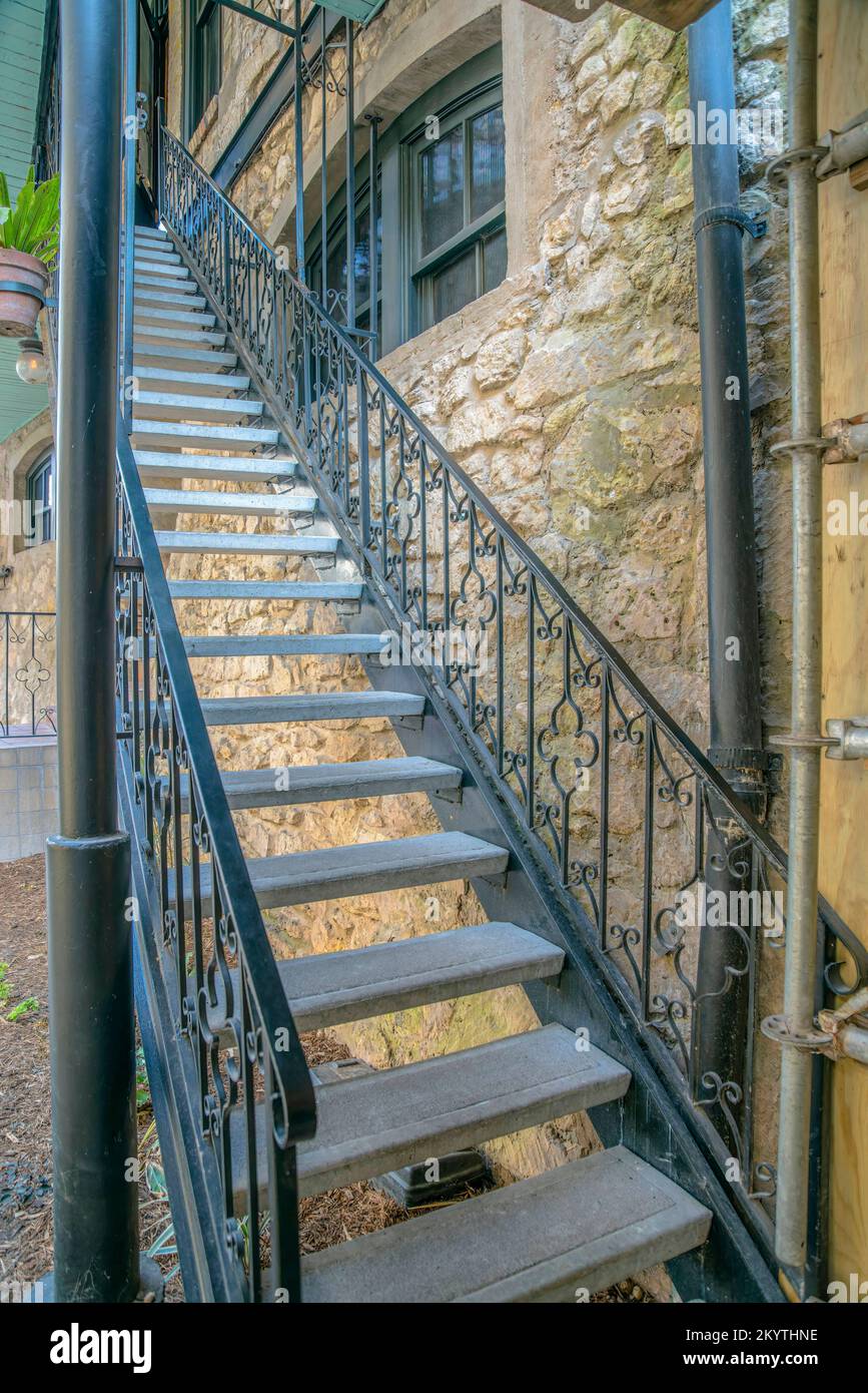 Narrow staircase with wrought iron railings near the stone wall at ...
