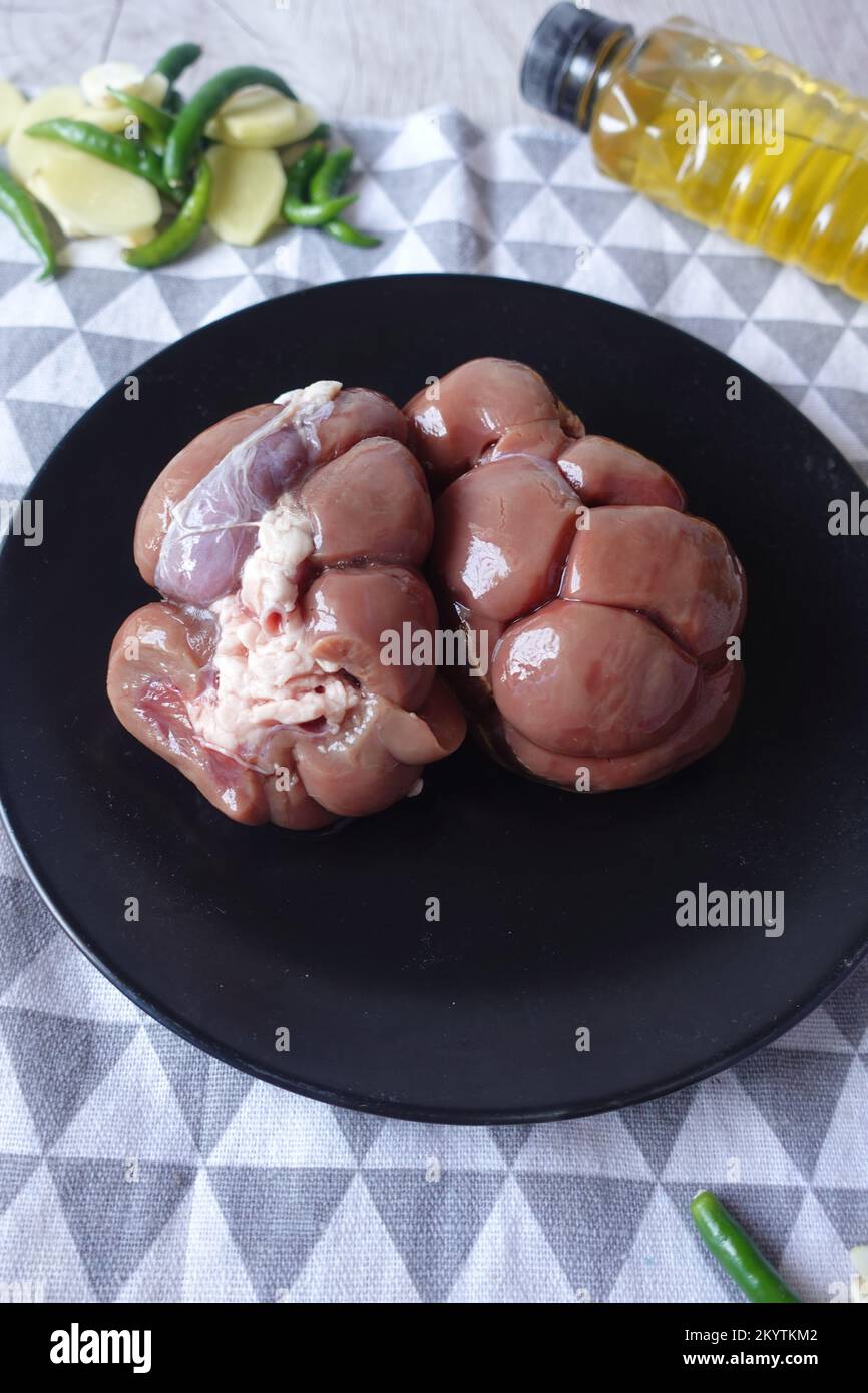 Raw fresh lamb kidneys on a chopping board  Stock Photo