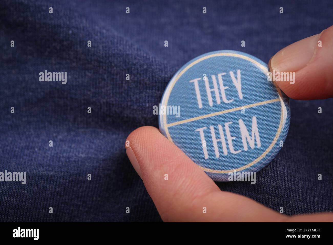 A person showing their They Them pronouns by wearing a badge. Stock Photo