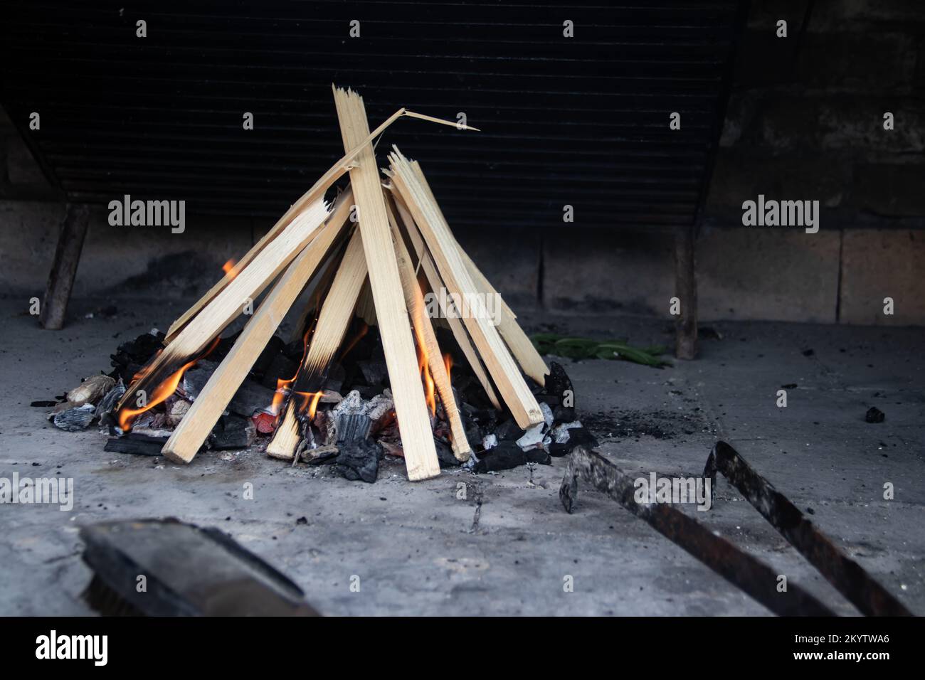 Small fire made of dried timber for barbeque preparation at picnic in