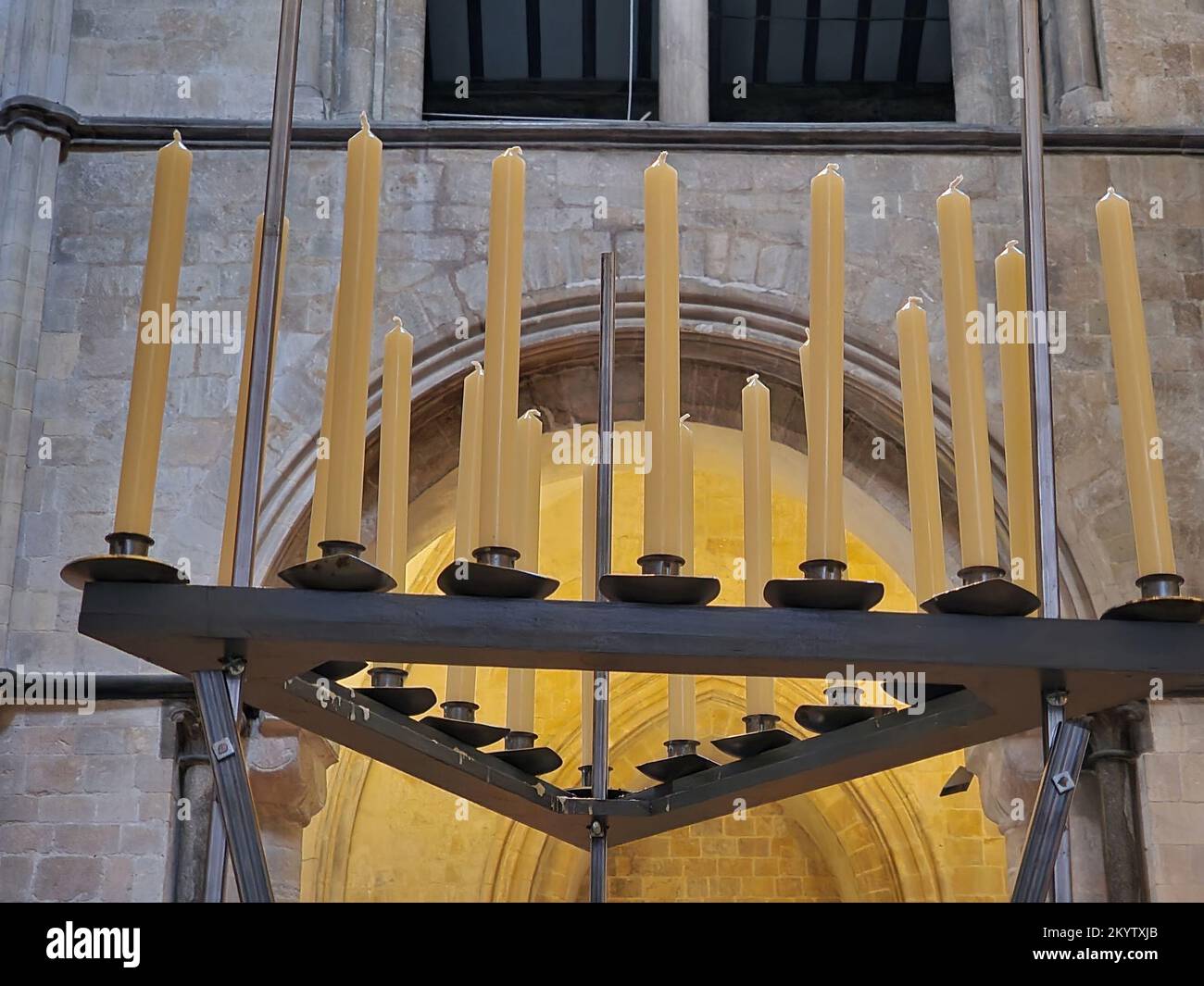 Close up of fresh new candle sticks seen in a black stand in the interior of a church building. Stock Photo